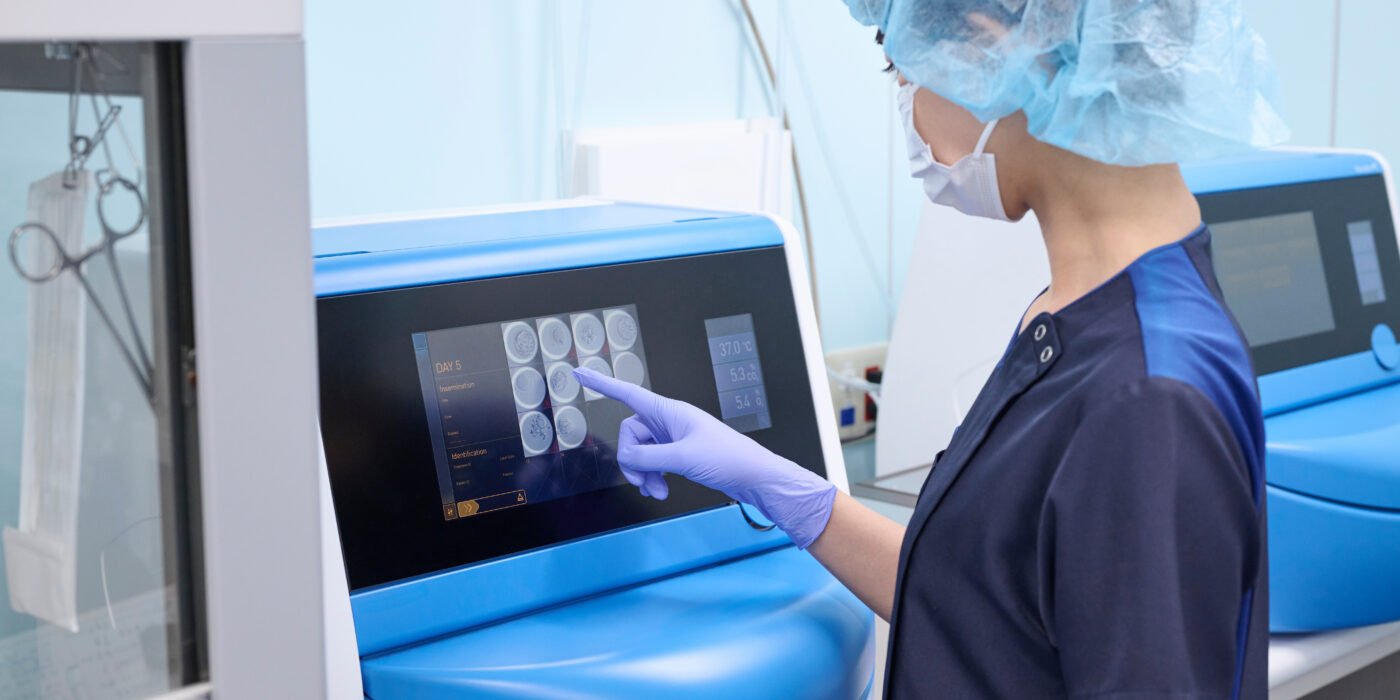 An embryologist in a modern laboratory uses an incubator for embryo cultivation.