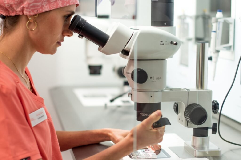 Embryologist examining embryos under a microscope in the IVF lab