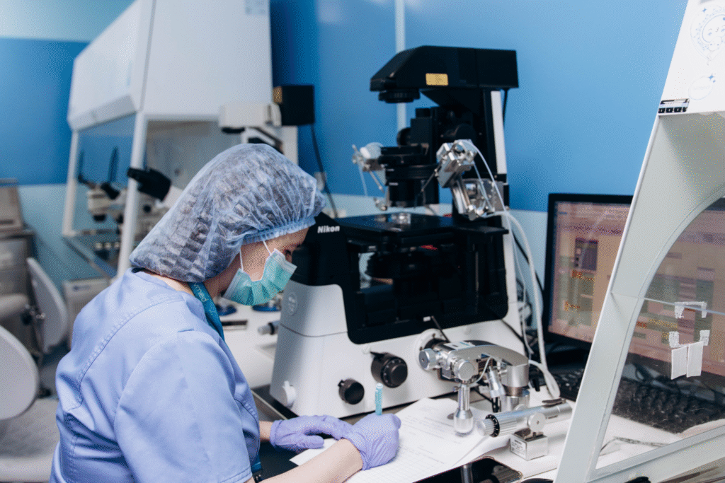 An embryologist working with a microscope in the IVF laboratory at IVMED Fertility Clinic Ukraine
